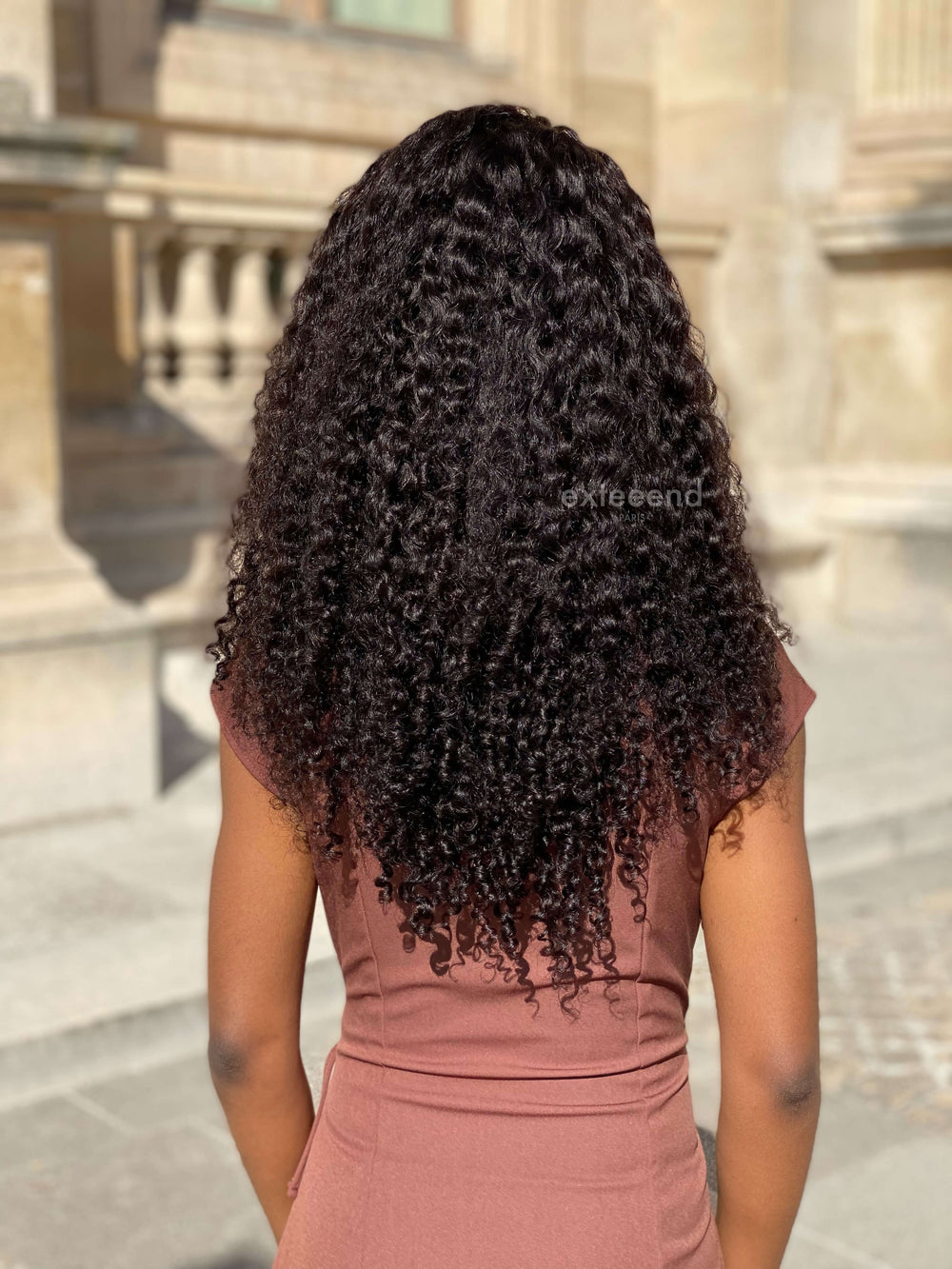 Perruque femme Tina bouclée kinky vue de dos lace wig lace front lace frontal invisible cheveux naturels virgin hair pose sans colle ni gel glueless Exteeend Paris